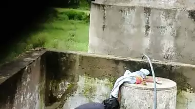 Indian village girl bathing near water tank outdoor